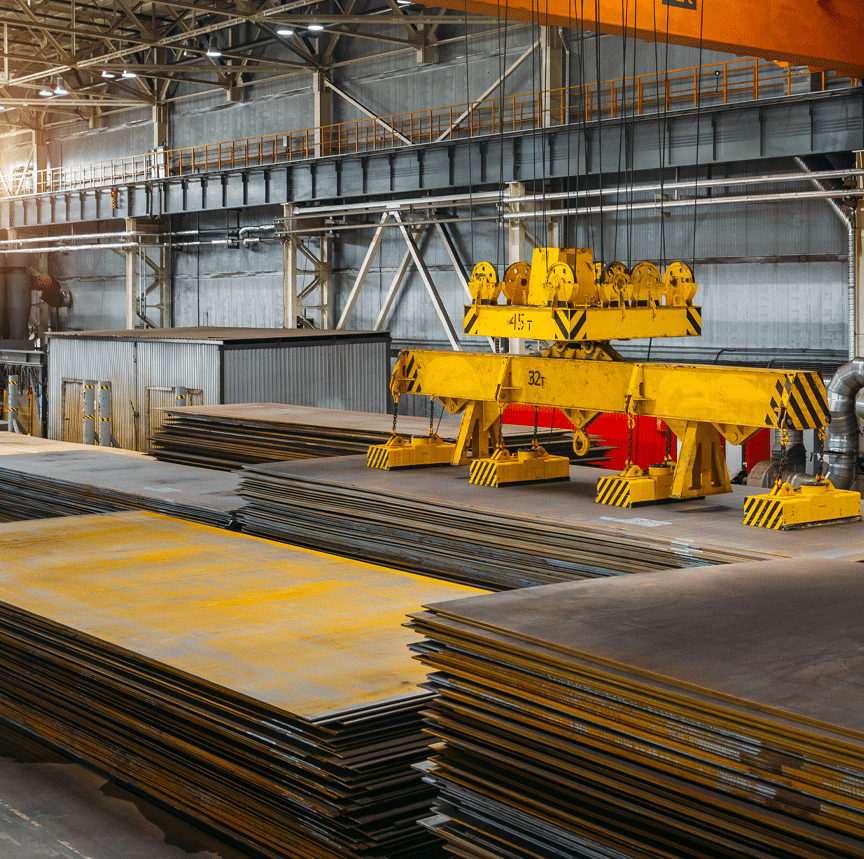 An overhead crane helps to move steel plates within a warehouse.