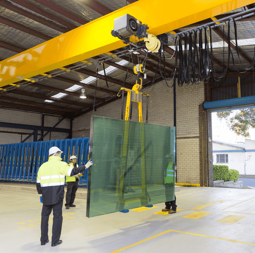Wire rope hoist and below-the-hook device moving glass panels for window construction