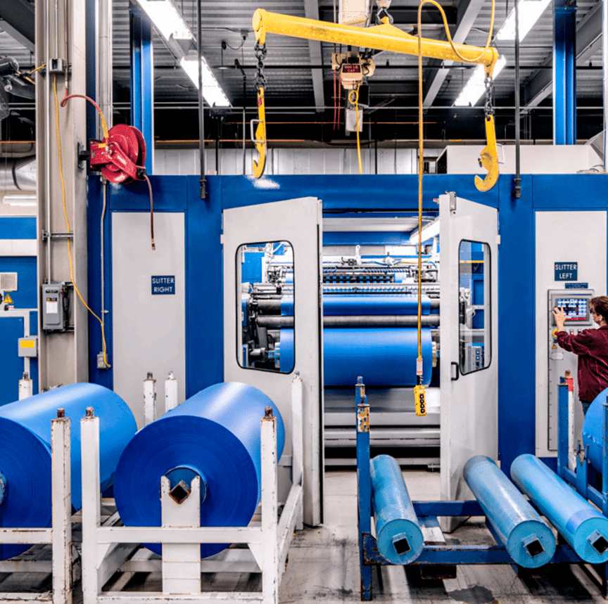 Overhead crane moving rolls of vinyl materials